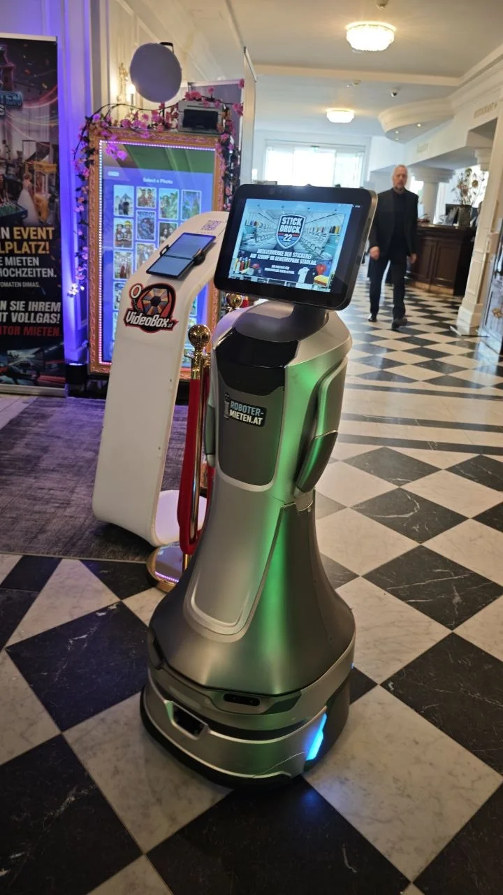 Gäste machen Fotos mit einem Begrüßungsroboter bei einem Event