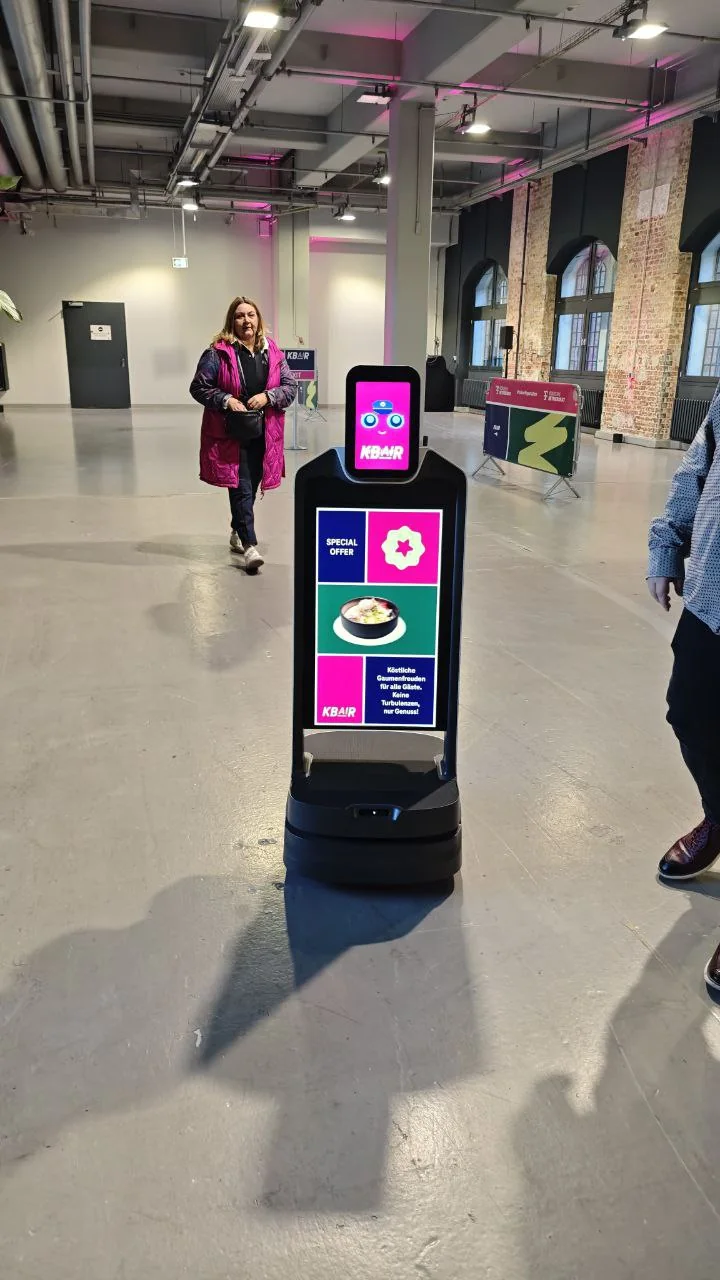 Roboter mit Kundenwerbung fährt durch Veranstaltung